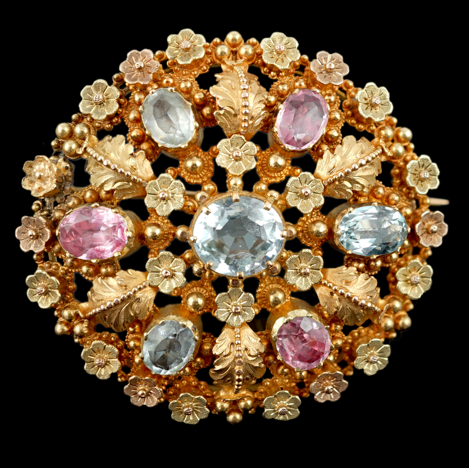 An early 20th century continental two colour gold, aquamarine and foil backed pink stone cluster set circular brooch